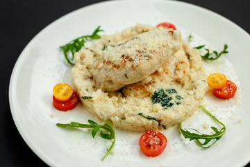 appetizing chicken breast with cheese, tomatoes and arugula with rice garnish