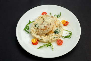 appetizing chicken breast with cheese, tomatoes and arugula with rice garnish