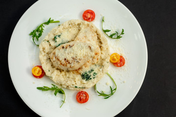 appetizing chicken breast with cheese, tomatoes and arugula with rice garnish