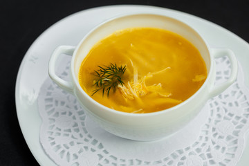 hot noodle soup with chicken and broth on a white plate