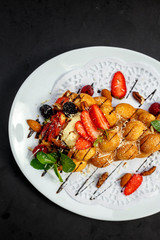 Waffles - a ball of Italian ice cream with berries and nuts and fresh fruit