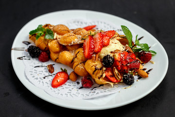 Waffles - a ball of Italian ice cream with berries and nuts and fresh fruit
