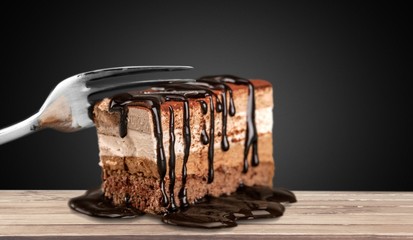 Tasty chocolate cake and fork on desk
