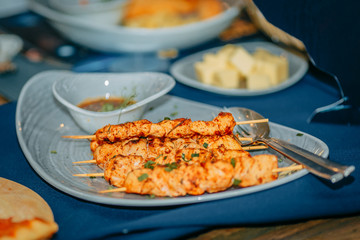 chicken skewers with sauce on a served table