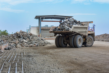 Huge industrial dump truck full loaded back view ready to unloading low angle