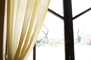 モダンな木の窓枠とクリーム色のカーテン