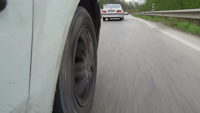 CHALUS, IRAN: Dolly Tracking low angel car driving wheel rolling pov close up in a road mounted camera