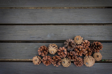 Pine cones on dark wooden background.