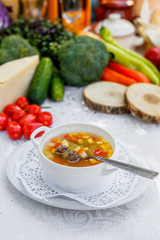vegetable soup with meatballs in a white plate on a white tablecloth