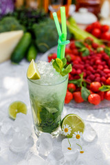 Cold cocktail mahito with ice on a decorated table