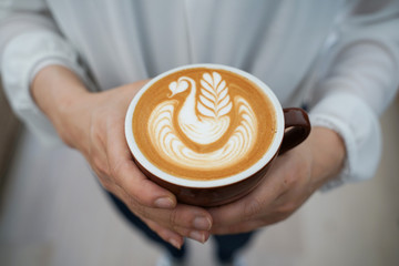 Latte art Coffee on hands at cafe © Daozlimited