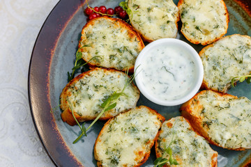 garlic bread with raw greens and sauce on a decorated table