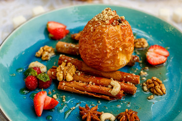 dessert, baked apple with nuts and berries on a decorated table