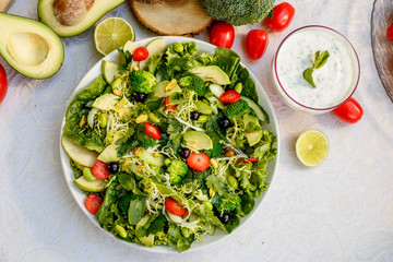 Detox, healthy vegetable salad with broccoli and avocado, healthy food on a decorated table