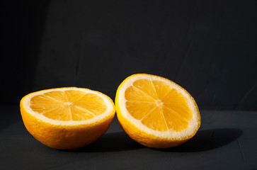 Two halves of fresh juicy lemon on  black background