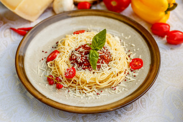 Pasta bolognese with minced meat and tomatoes with greens on the decorated table