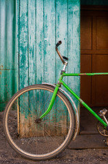 Fototapeta na wymiar Old green bike on wooden aqua wall background vintage..