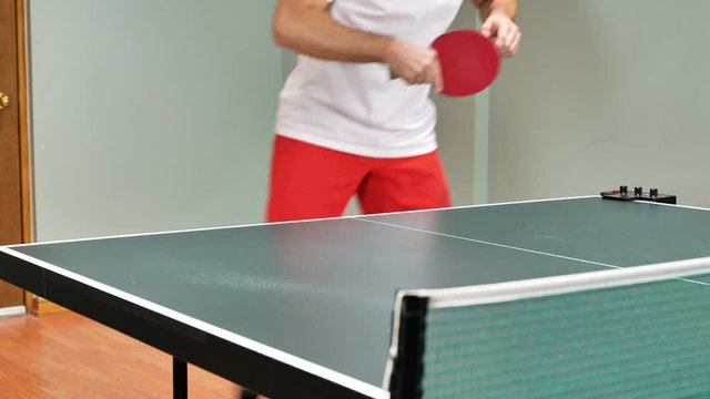 Man playing table tennis with robot automatic feed balls system. forehand backhand hit after service close-up shot without head