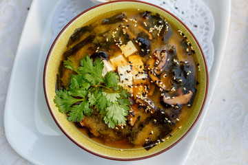 Thai soup tom yam with seafood and cheese on decorated table