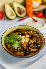 Thai soup tom yam with seafood and cheese on decorated table