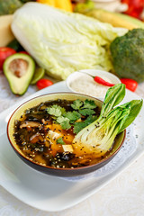 Thai soup tom yam with seafood and cheese on decorated table