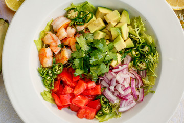 Salad with shrimps and vegetables, healthy food on the decorated table