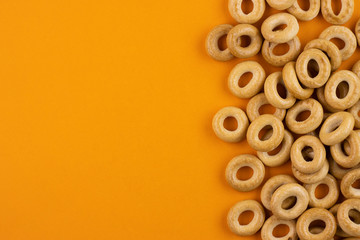 Round bagels close-up on a red background. A pile of scattered bagels