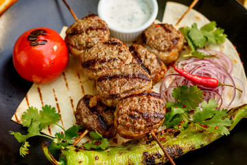 kebab with pita bread and grilled vegetables on a decorated table