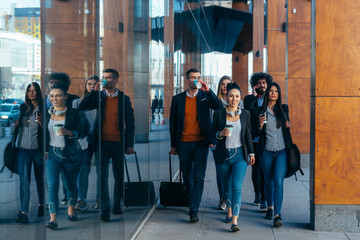 Group of colleagues on a business trip (euro trip) walking together at a modern  futuristic station