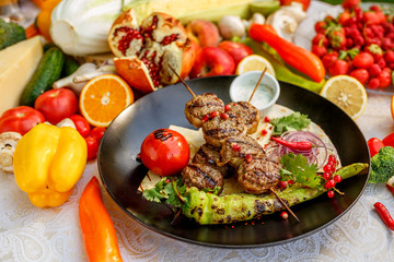 kebab with pita bread and grilled vegetables on a decorated table