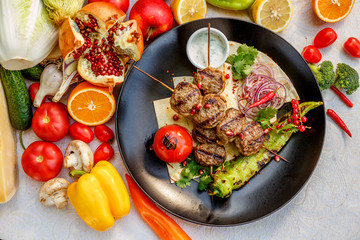 kebab with pita bread and grilled vegetables on a decorated table