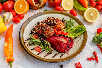 chicken thighs with rucola, nuts and vegetables on a decorated table