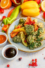 broccoli fried in breading with vegetables with sauces on a decorated table