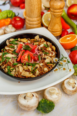 buckwheat with mushrooms, green onions and vegetables on the decorated table