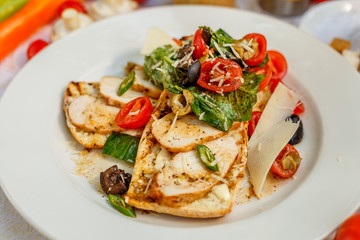 Fototapeta na wymiar panini with chicken and vegetables on a plate on a decorated table