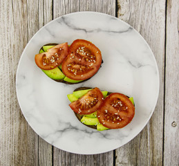 Avocado sandwich with layers of tomato and flaxseeds