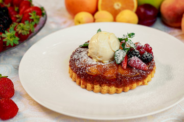 dessert, belgian waffle with a scoop of ice cream and berries in a white plate on a white table
