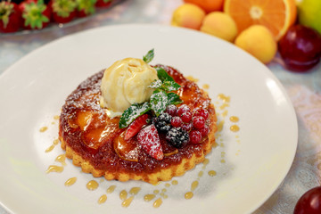 dessert, belgian waffle with a scoop of ice cream and berries in a white plate on a white table