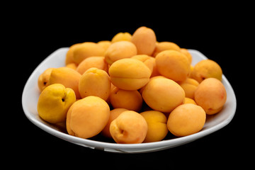 Fototapeta na wymiar apricot in a white plate, on a black background, healthy food