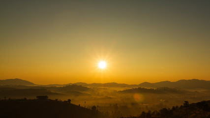 The morning sun and the orange sky are above the mountains.