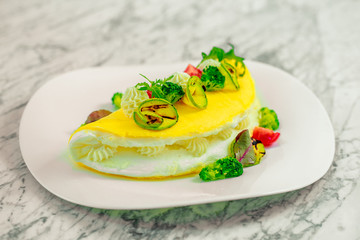 omelet with cheese and vegetables on a white plate