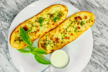Garlic bread with cheese and herbs with sauce. Beautiful pitch
