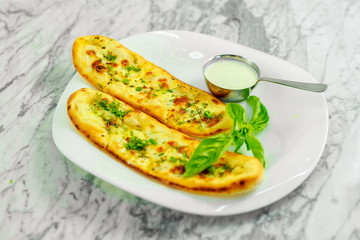 Garlic bread with cheese and herbs with sauce. Beautiful pitch