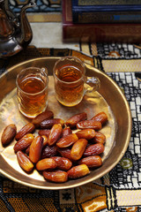 Dates fruit and Islamic Book Koran on carpet background, Islamic background in mosque