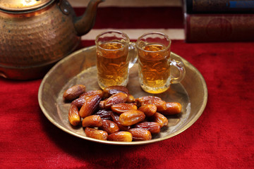 Dates fruit and Islamic Book Koran on carpet background, Islamic background in mosque