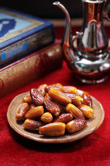 Dates fruit and Islamic Book Koran on carpet background, Islamic background in mosque