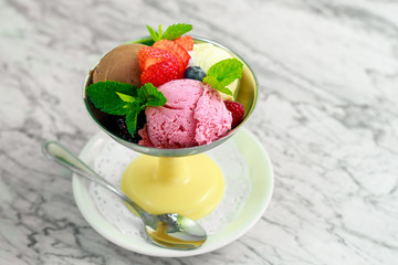 three balls of ice cream with berries and mint, a beautiful serving