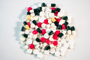 Coronavirus Covid -19. A handful of multi-colored medical pills lies on a white background.