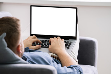 Young Man Using Laptop At Home