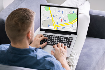 Man Using GPS Map On Laptop
